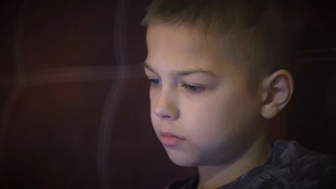 CU Portrait of a little boy of 8 - 11 years old staring at the movie at night Stock Footage 101029026
