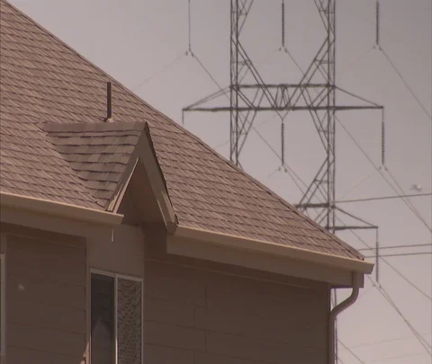 CU power lines seen over roof of house Stock Footage 86691559