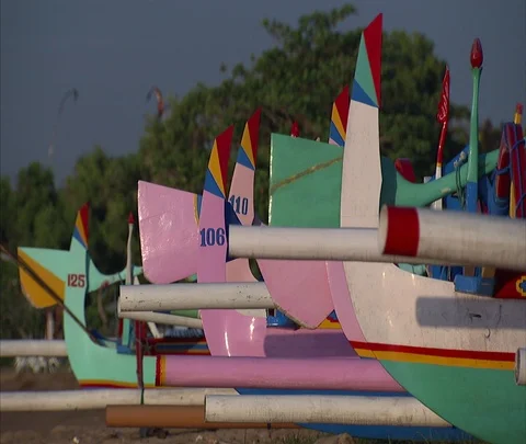 CU row of brightly colored boats lined up on the sand Stock Footage 86747875