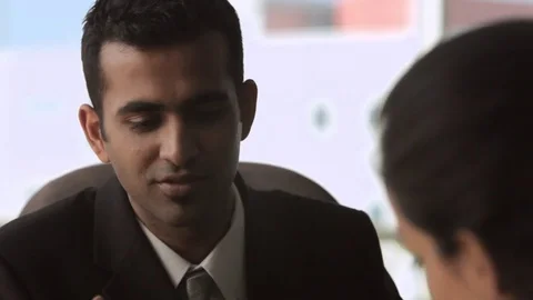 CU SELECTIVE FOCUS Business couple sitting and talking in office Stock Footage 69933650