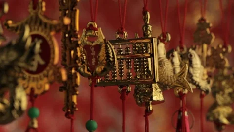 CU SELECTIVE FOCUS Gold decorations hanging from red strings, depicting good Stock Footage 69953230
