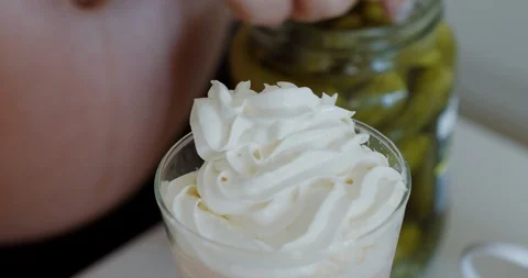 CU shot of milkshake while pregnant woman adding pickles in it. Stock Footage 111539789