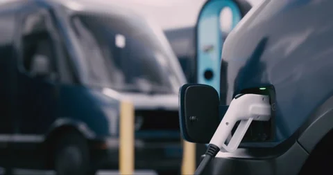 CU shot of modern electric EV delivery vans charging in company parking garage Stock Footage 239049836