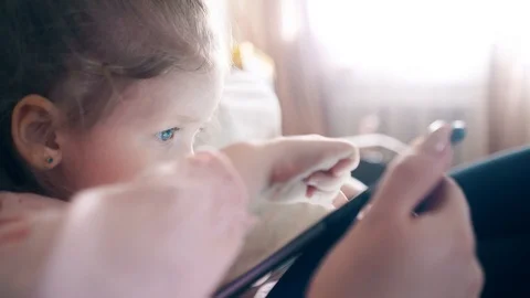 CU: Side view, 4k: Young attractive mother and sweet daughter are sitting on the Stock Footage 105117326