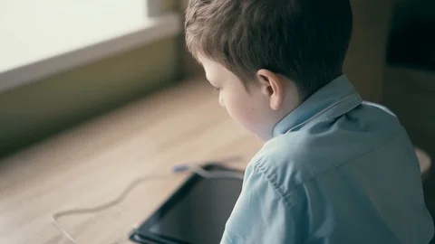 CU, Slow motion: child, a schoolboy, sits at a table and thinks that there is a Stock Footage 105100897