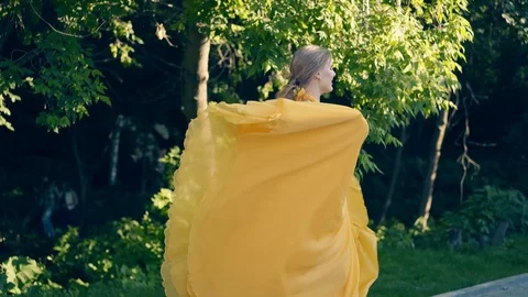 CU, Slow motion: Young beautiful girl, in beautiful yellow fluttering dress Stock Footage 104618286