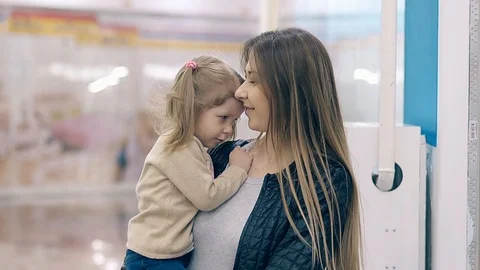 CU, Slow motion: Young beautiful mother hugs a little daughter, they are in a Stock Footage 105121239