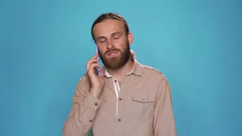 CU studio portrait of young attractive male is talking by phone Stock Footage 157884249