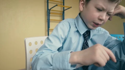 CU, Tracking: Pupil works on tablet computer, does lessons, flips through pages Stock Footage 105099430