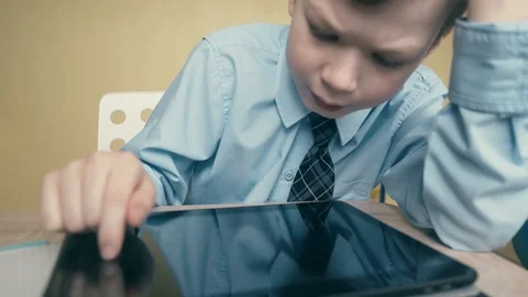 CU, Tracking: Pupil works on a tablet computer, does lessons, flips through Stock Footage 105099661