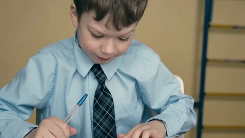 CU, Tracking: schoolboy does homework, writes a pen in a notebook, uses a Stock Footage 105097750