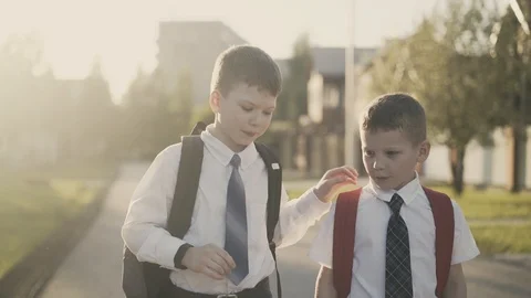 CU, Tracking: Two schoolchildren go home after school, they talk, smile, hug Stock Footage 105145197