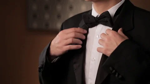 CU TU Portrait of young man fixing his tuxedo and smiling / China Stock Footage