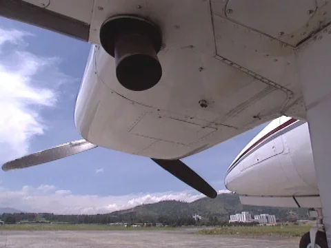 C/u underneath Cessna aircraft, propeller turns and exhaust pipe shakes Stock Footage 86753050