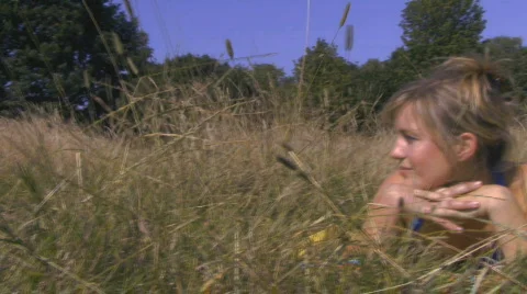 CU OF A WOMAN LYING IN A FIELD SMILING Stock Footage 542425