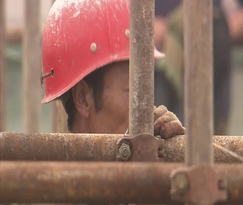 CU workers in hard hats secure scaffolding on construction site Stock Footage 86744297
