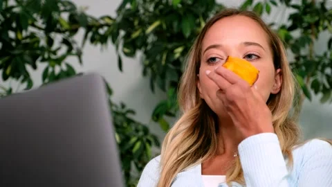 CU Young attractive woman using laptop chatting in social media eating peach Stock Footage 161838623