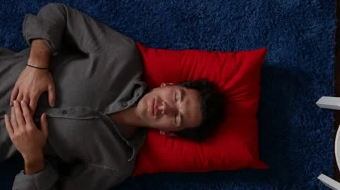 CU, ZO, man lying on a rug next to his home office desk, overhead view Stock Footage