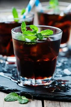Cuba libre with ice and mint, selective focus Stock Photos
