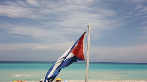 Cuban flag on the beach, flying in the wind on background of ocean. Cuba, Varade Stock Footage 112045911
