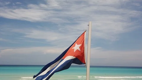 Cuban flag on the beach, flying in the wind on background of ocean. Cuba, Varade Stock Footage 112050129
