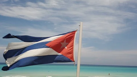 Cuban flag on the beach, flying in the wind on background of ocean. Cuba, Varade Stock Footage 112077549