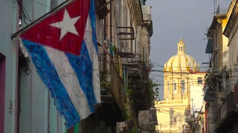 The Cuban flag flies in front of a scene in the Old City of Havana, Cuba. 库存影片 66759652