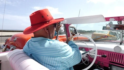 Cuban Man Driving in a Classic American Vintage Taxi Car Through Havana Cuba Stock Footage
