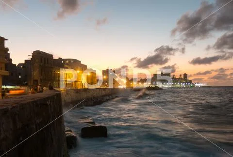 Cubans contemplate the sunset in the famous malecon in Havana, Cuba Stock Photos