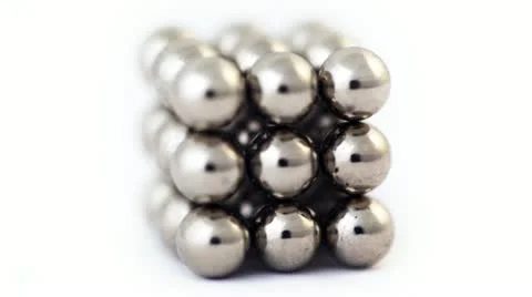 Cube assembled from little metallic magnetic balls rotating Stock Footage
