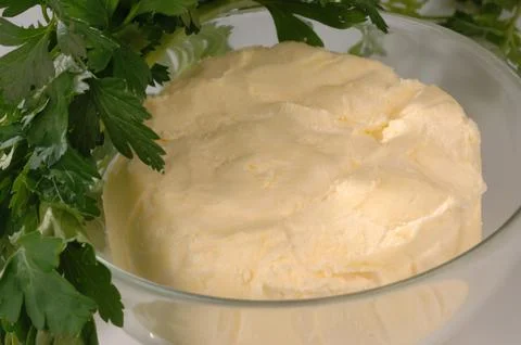Cube of butter in a container on a light background 스톡 사진
