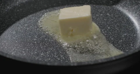 Cube of butter melting in a frying pan. Close-up shot Stock Footage 250226536