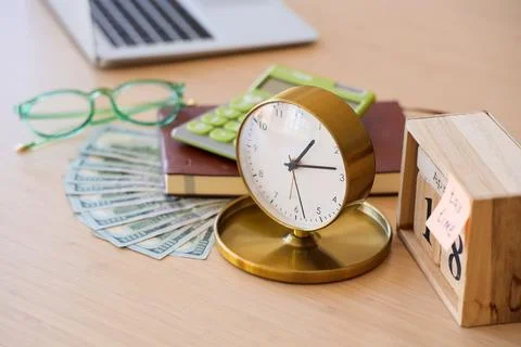 Cube calendar with text TAX TIME, alarm clock, calculator and dollars on tabl Stock Photos