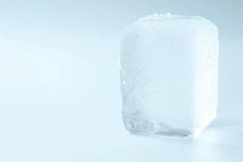 Cube of clear ice on light blue background, space for text Foto stock