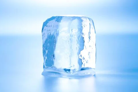 Cube of clear ice on light blue background 스톡 사진