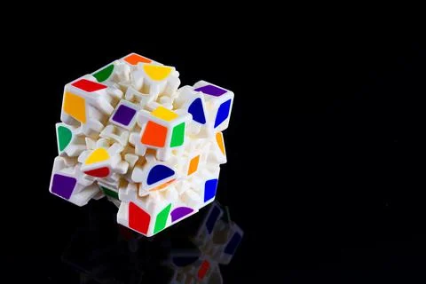 This is a cube with colored faces puzzle on a dark background with reflection. A Stockfoto's
