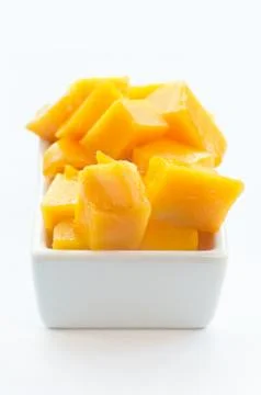 Cube cut mango on a white dish against white background Foto stock