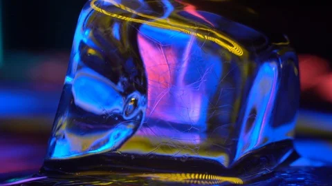 Cube of ice close-up in yellow neon lighting 4K Stock Footage 106831242