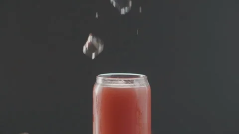 Cube of ice falls into refreshing fruit cocktail Stock Footage 97754164