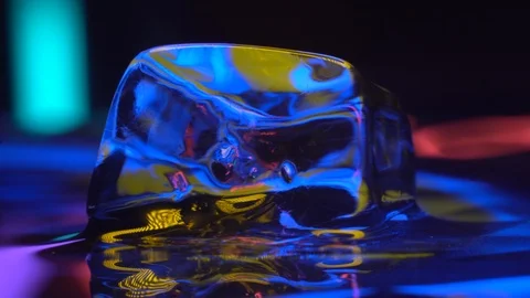 Cube of ice rotating in yellow neon lighting Stock Footage 106830217