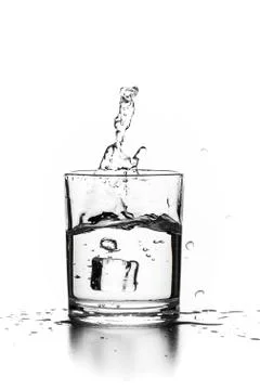 Cube of ice thrown into a glass with liquid Stock Photos