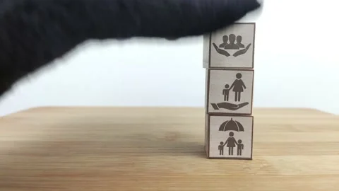 Cube, Insurance and stages of life concept. Hand puts wooden cube with assurance Stock Footage