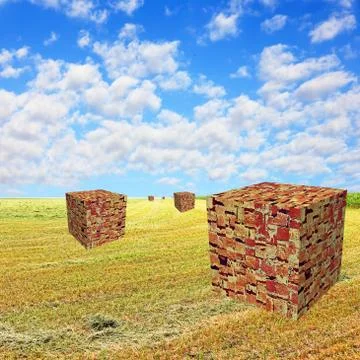 Cube shape brick stacks on yellow field against blue cloudy sky. Foto stock