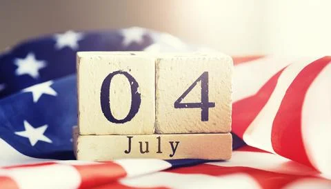 Cube shape calendar for July 04 on wooden table on usa flag background Stock Photos