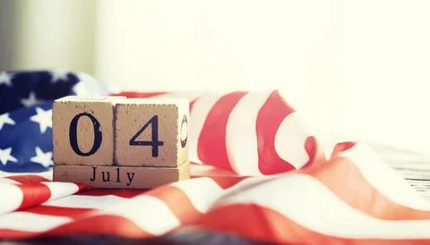 Cube shape calendar for July 04 on wooden table on usa flag background Stock Photos