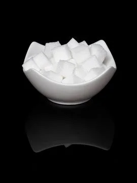 Cube sugar, sugar cubes in an angular shell in front of black background, w.. Stock Photos