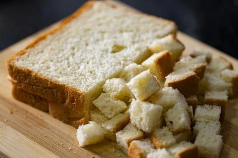 Cubed White Bread on Wooden Cutting Board for Homemade Croutons Stock Photos