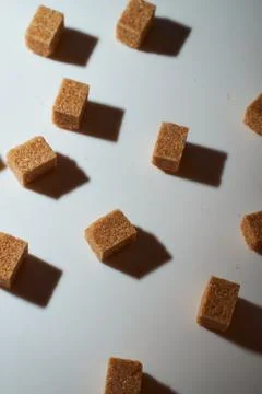 Cubes of cane sugar on a white background with a shadow. Top view. Stock Photos