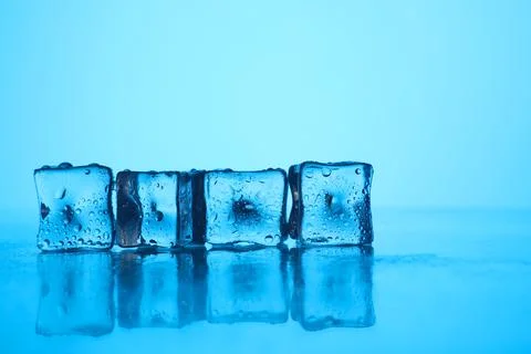 Cubes of clear ice on light blue background, closeup. Space for text Stock Photos