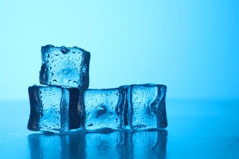 Cubes of clear ice on light blue background, closeup. Space for text Foto stock